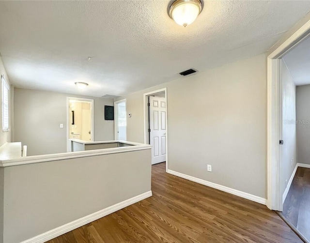 interior space with a textured ceiling, dark hardwood / wood-style floors, and a healthy amount of sunlight