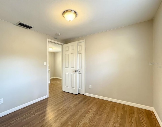 unfurnished room with wood-type flooring