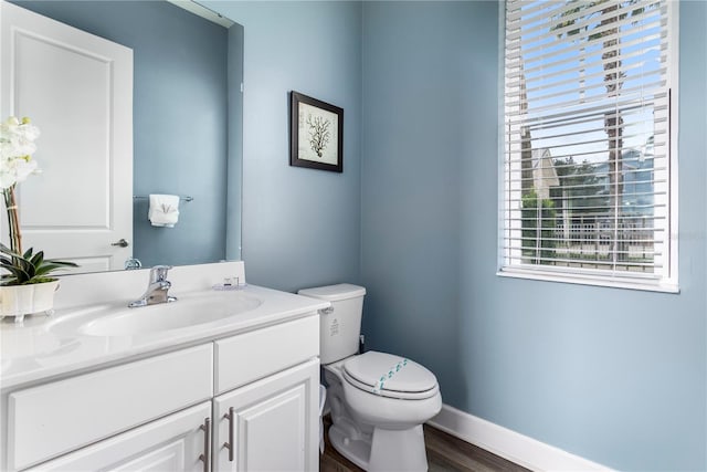 bathroom with hardwood / wood-style floors, vanity, and toilet