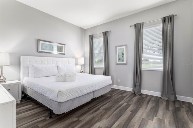 bedroom with dark hardwood / wood-style floors and multiple windows