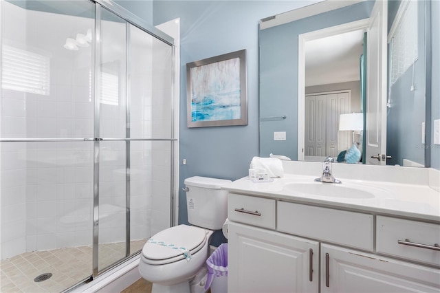 bathroom featuring a shower with door, vanity, and toilet