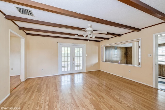 unfurnished living room featuring light wood-type flooring, beamed ceiling, ceiling fan, french doors, and a textured ceiling