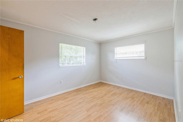 empty room with light hardwood / wood-style floors, crown molding, and a healthy amount of sunlight