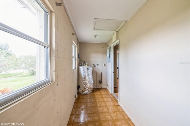 hallway with light parquet floors and tile walls