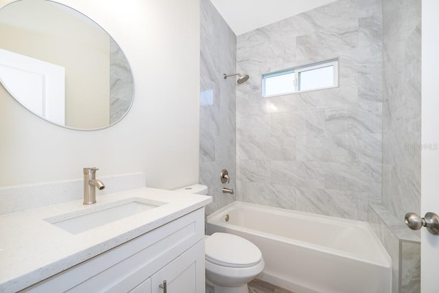 full bathroom featuring tiled shower / bath, vanity, and toilet