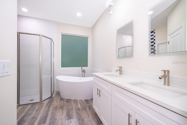 bathroom with vanity, hardwood / wood-style flooring, and plus walk in shower