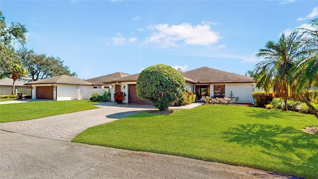 single story home featuring a front lawn and a garage