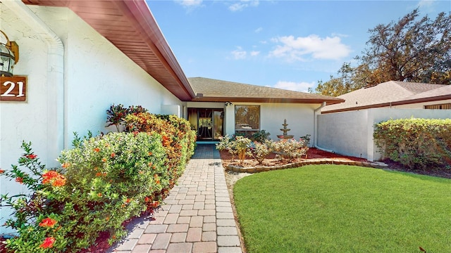 view of exterior entry with a yard