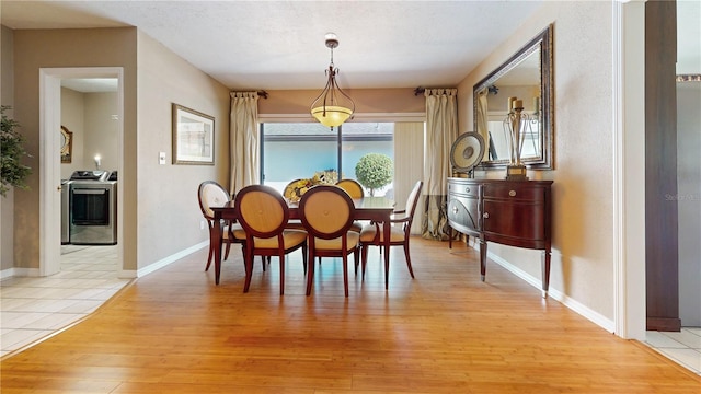 dining area featuring light hardwood / wood-style flooring, a textured ceiling, and washer / clothes dryer