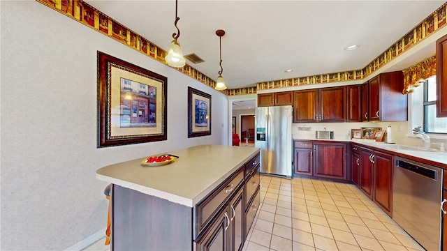 kitchen with a kitchen island, sink, pendant lighting, light tile patterned floors, and appliances with stainless steel finishes