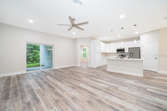 unfurnished living room featuring light hardwood / wood-style floors, a wealth of natural light, and ceiling fan