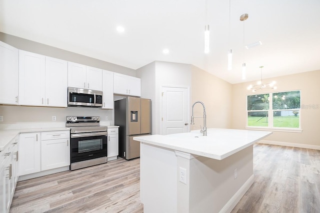 kitchen featuring pendant lighting, white cabinetry, light hardwood / wood-style flooring, appliances with stainless steel finishes, and a center island with sink