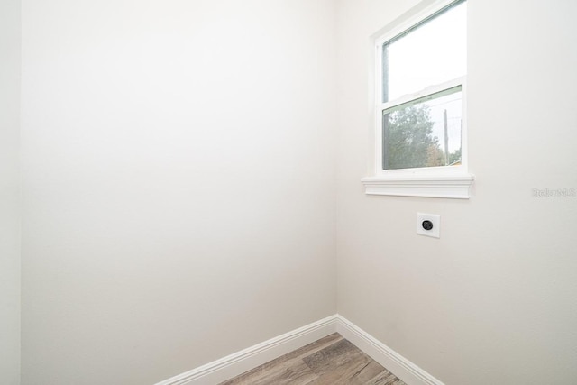 clothes washing area featuring hardwood / wood-style flooring and hookup for an electric dryer