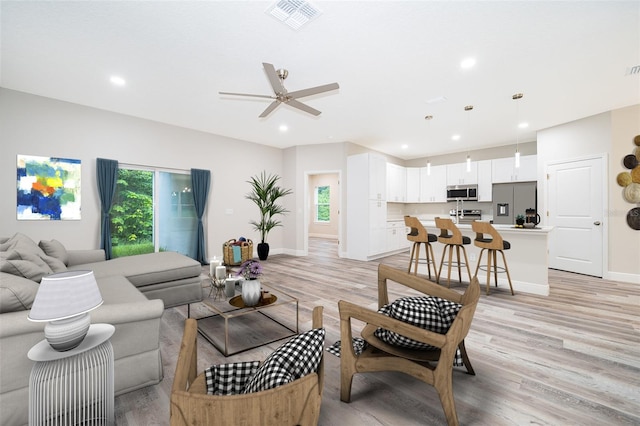 living room featuring light hardwood / wood-style floors and ceiling fan