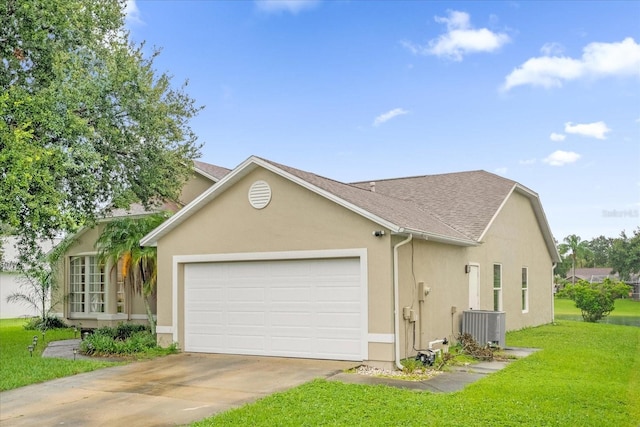 view of front of home with cooling unit, a front lawn, and a garage