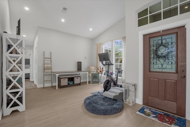 entrance foyer with light hardwood / wood-style floors and high vaulted ceiling