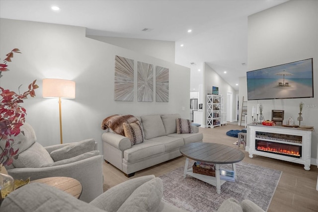 living room with light hardwood / wood-style flooring and high vaulted ceiling