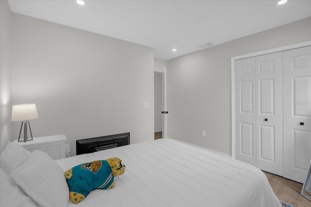 bedroom with light carpet and a closet