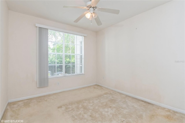 carpeted spare room featuring ceiling fan