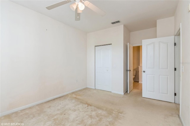 unfurnished bedroom with a closet, light colored carpet, and ceiling fan