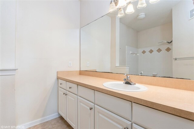 bathroom featuring vanity, tile patterned flooring, and tiled shower