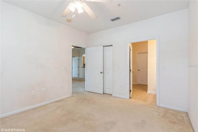 unfurnished bedroom featuring light carpet, a closet, and ceiling fan