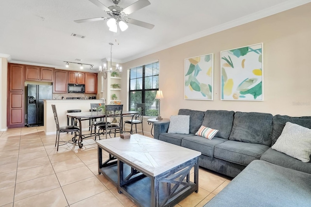 living room with ceiling fan with notable chandelier, ornamental molding, and light tile patterned flooring