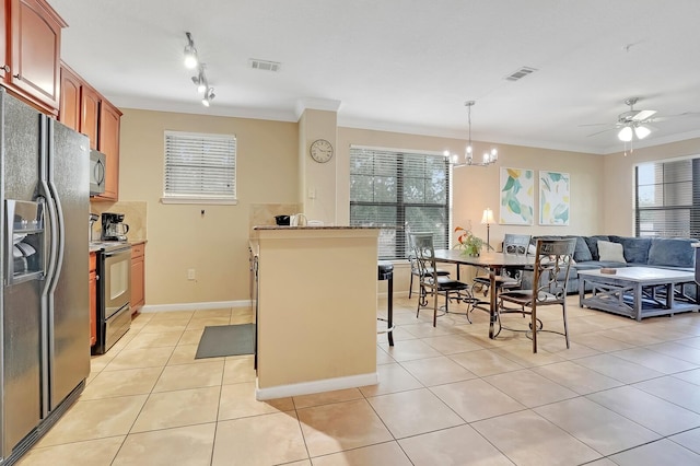 kitchen with pendant lighting, light tile patterned flooring, ornamental molding, appliances with stainless steel finishes, and a kitchen breakfast bar