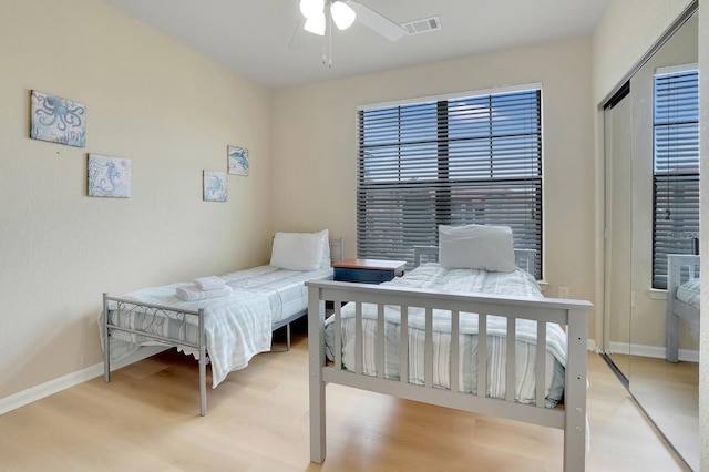 bedroom with ceiling fan, a closet, and light hardwood / wood-style flooring