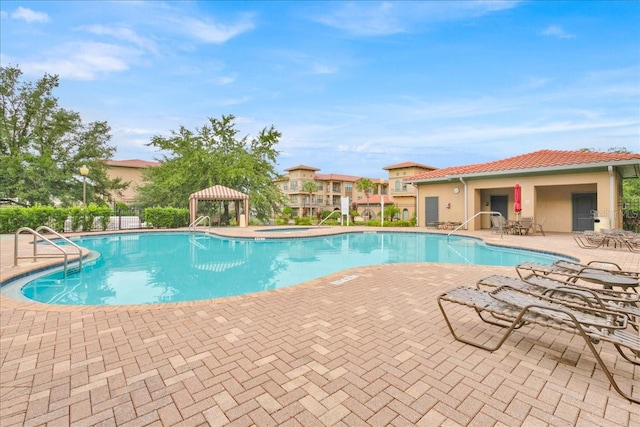 view of pool with a gazebo, a community hot tub, and a patio