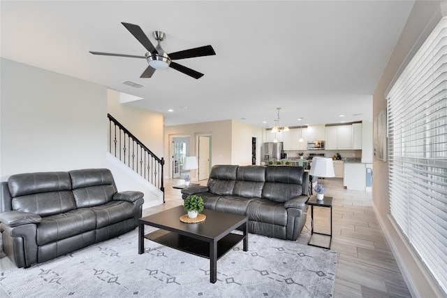 living room featuring light hardwood / wood-style floors and ceiling fan