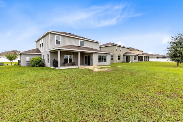 back of property with a lawn and a patio area