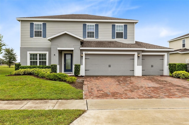 view of front property featuring a front lawn and a garage