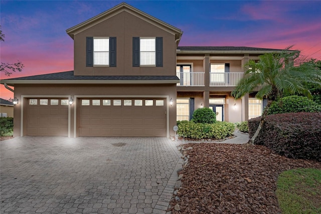 view of front of property featuring a garage and a balcony