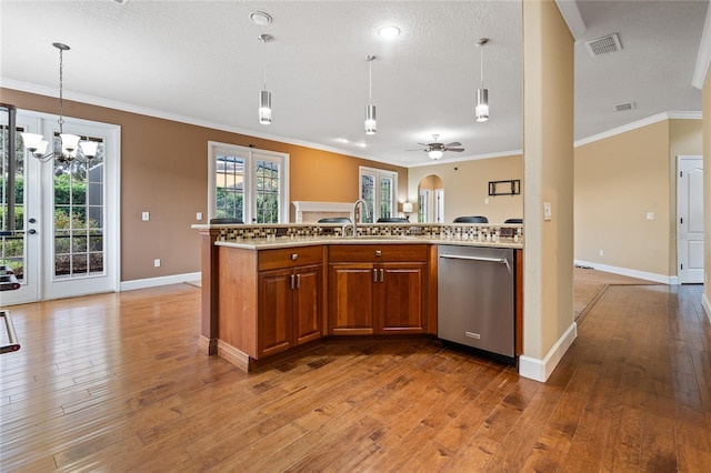 kitchen with hardwood / wood-style floors, stainless steel dishwasher, ceiling fan with notable chandelier, pendant lighting, and crown molding