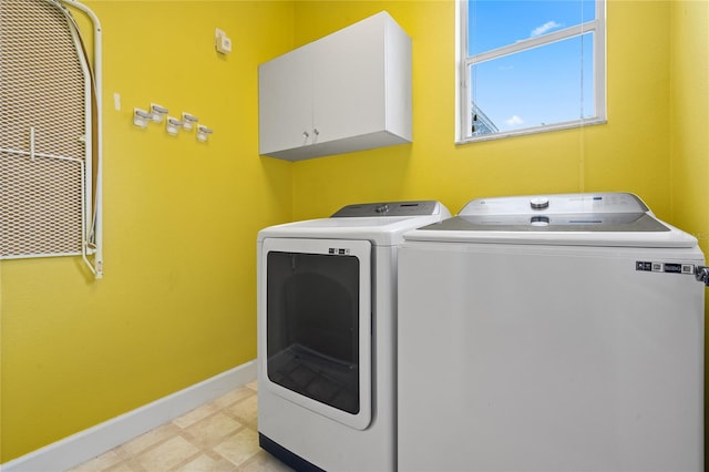 laundry area with independent washer and dryer and cabinets