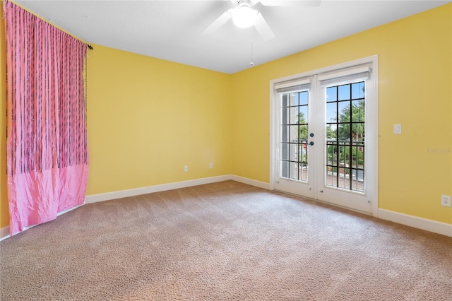 carpeted spare room featuring french doors and ceiling fan