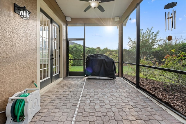 unfurnished sunroom featuring ceiling fan