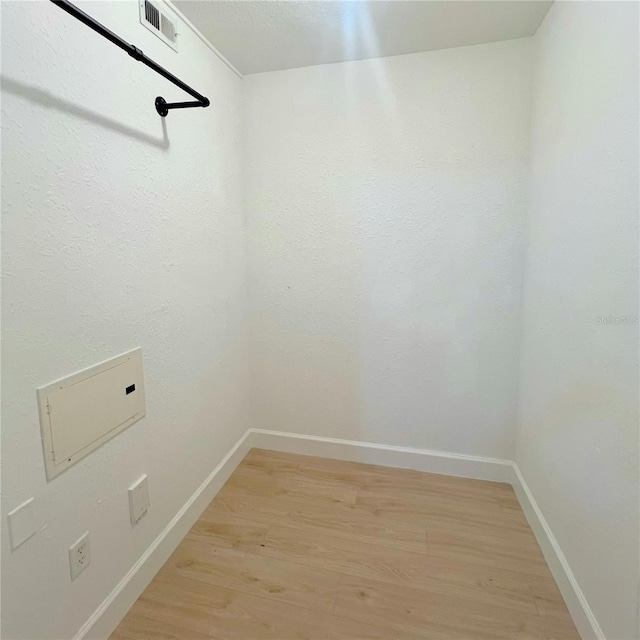 clothes washing area featuring light hardwood / wood-style floors