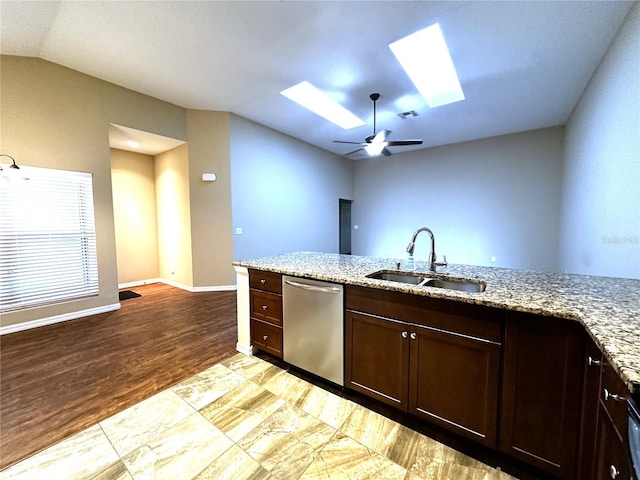 kitchen featuring light wood-type flooring, lofted ceiling with skylight, sink, dishwasher, and light stone countertops