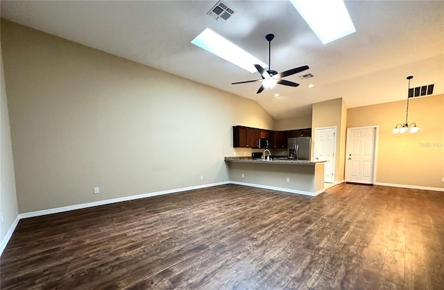 unfurnished living room with high vaulted ceiling, sink, dark hardwood / wood-style flooring, ceiling fan with notable chandelier, and a skylight