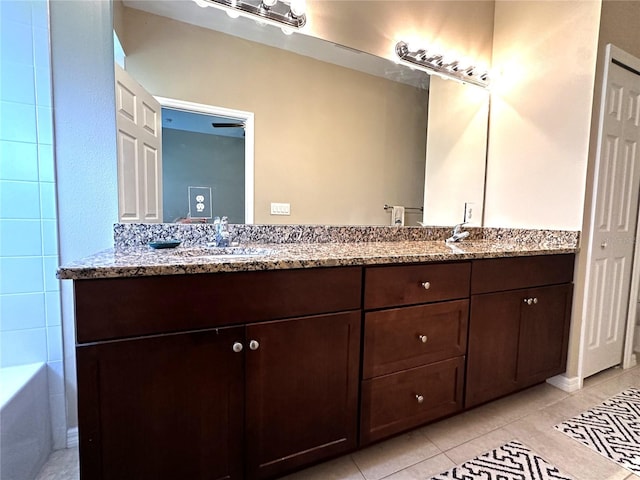 bathroom with vanity, a bath, and tile patterned floors