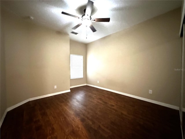 empty room with ceiling fan and dark hardwood / wood-style floors