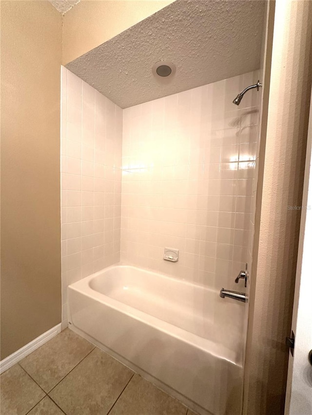 bathroom featuring tiled shower / bath combo, tile patterned floors, and a textured ceiling