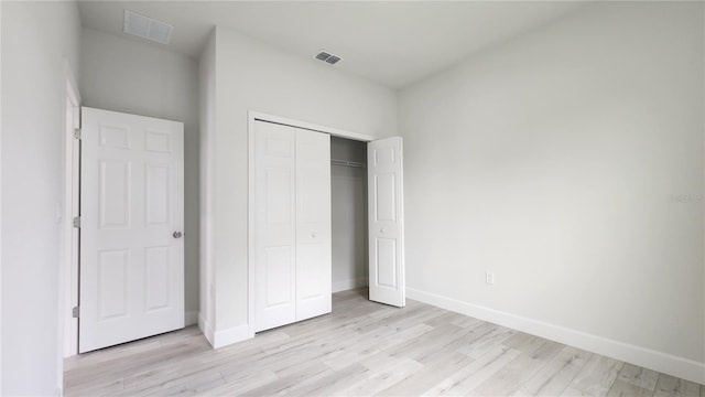 unfurnished bedroom with light hardwood / wood-style floors and a closet