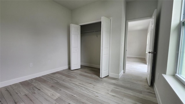 unfurnished bedroom with light hardwood / wood-style floors and a closet