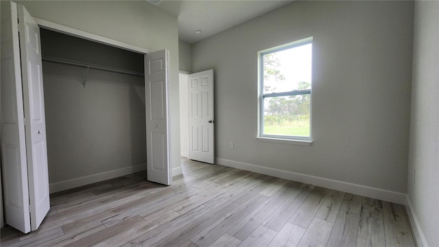 unfurnished bedroom with a closet and light hardwood / wood-style floors