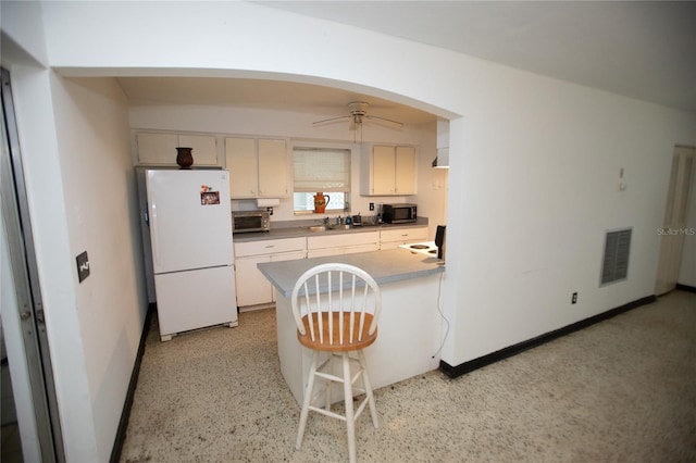 kitchen featuring white fridge, ceiling fan, and sink