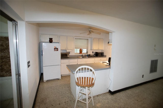 kitchen featuring white fridge, ceiling fan, white cabinetry, and sink