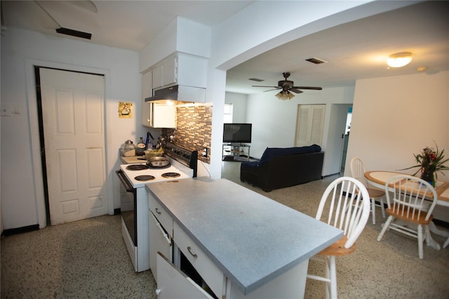 kitchen with ceiling fan, decorative backsplash, white electric stove, a breakfast bar, and white cabinets